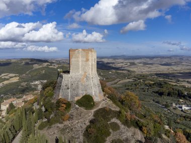 İtalya 'nın Toskana kentindeki tepelerde sonbaharda ortaçağ kalesi ve manzarası