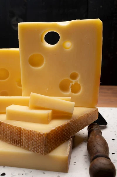 Swiss cheese collection, holes emmentaler and gruyere cheese made from unpasteurized cow\'s milk close up