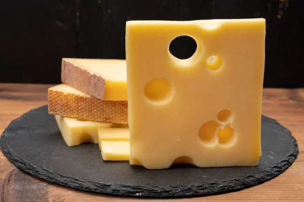 Swiss cheese collection, emmentaler with holes,  gruyere, appenzeller fondue cheeses close up