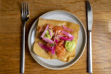 Meksika yemeği, kızarmış mısır tortilla füme somon, guacamole sosu ve pembe soğan turşusu.
