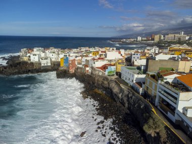 Puerto de la Cruz, Tenerife yakınlarındaki Punta Brava adlı küçük balıkçı köyünde renkli evler ve siyah lav kayaları üzerindeki hava manzarası, kışın İspanya 'da Kanarya Adaları