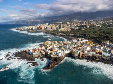 Puerto de la Cruz, Tenerife yakınlarındaki Punta Brava adlı küçük balıkçı köyünde renkli evler ve siyah lav kayaları üzerindeki hava manzarası, kışın İspanya 'da Kanarya Adaları