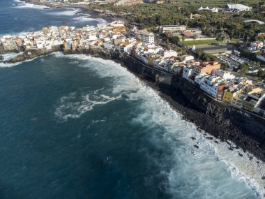 Puerto de la Cruz, Tenerife yakınlarındaki Punta Brava adlı küçük balıkçı köyünde renkli evler ve siyah lav kayaları üzerindeki hava manzarası, kışın İspanya 'da Kanarya Adaları