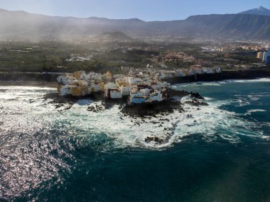 Renkli evlere hava manzarası, Teide Dağı tepesi ve küçük balıkçı köyü Punta Brava 'daki siyah lav kayaları Puerto de la Cruz, Tenerife, Kanarya Adaları, İspanya kışın