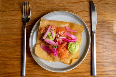Meksika yemeği, kızarmış mısır tortilla füme somon, guacamole sosu ve pembe soğan turşusu.
