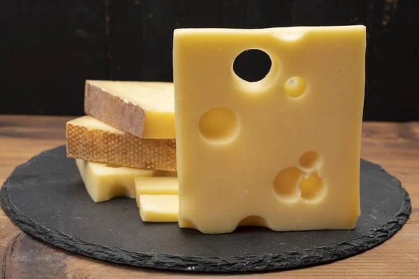 Swiss cheese collection, emmentaler with holes,  gruyere, appenzeller fondue cheeses close up