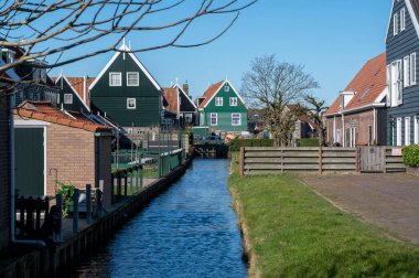 Hollanda 'nın küçük Marken kasabasında güneşli bir bahar gününde eski Hollanda, Hollanda' da bulunan ahşap evlerle yürüyorum.