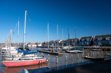 Hollanda 'nın küçük Marken kasabasında güneşli bir bahar gününde eski Hollanda, Hollanda' da bulunan ahşap evlerle yürüyorum.