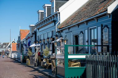 Hollanda 'nın küçük Marken kasabasında güneşli bir bahar gününde eski Hollanda, Hollanda' da bulunan ahşap evlerle yürüyorum.