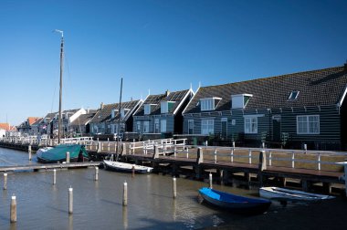 Hollanda 'nın küçük Marken kasabasında güneşli bir bahar gününde eski Hollanda, Hollanda' da bulunan ahşap evlerle yürüyorum.