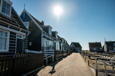 Hollanda 'nın küçük Marken kasabasında güneşli bir bahar gününde eski Hollanda, Hollanda' da bulunan ahşap evlerle yürüyorum.