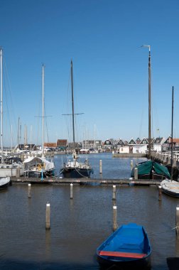 Hollanda 'nın küçük Marken kasabasında güneşli bir bahar gününde eski Hollanda, Hollanda' da bulunan ahşap evlerle yürüyorum.