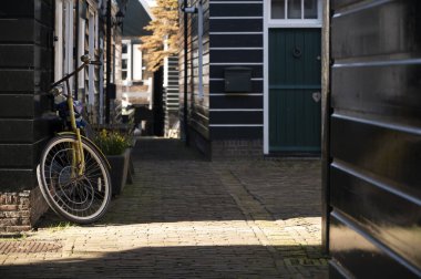 Hollanda 'nın küçük Marken kasabasında güneşli bir bahar gününde eski Hollanda, Hollanda' da bulunan ahşap evlerle yürüyorum.