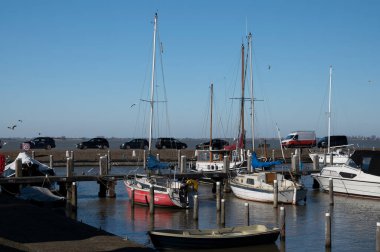 Hollanda 'nın küçük Marken kasabasında güneşli bir bahar gününde eski Hollanda, Hollanda' da bulunan ahşap evlerle yürüyorum.