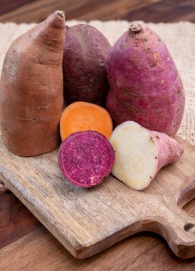 Renkli kök sebzeler pembe, mor ve turuncu organik tatlı patatesler yakın çekim