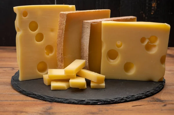 Swiss cheese collection, emmentaler with holes,  gruyere, appenzeller fondue cheeses close up