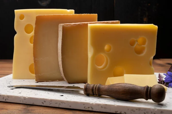 Swiss cheese collection, emmentaler with holes,  gruyere, appenzeller fondue cheeses close up