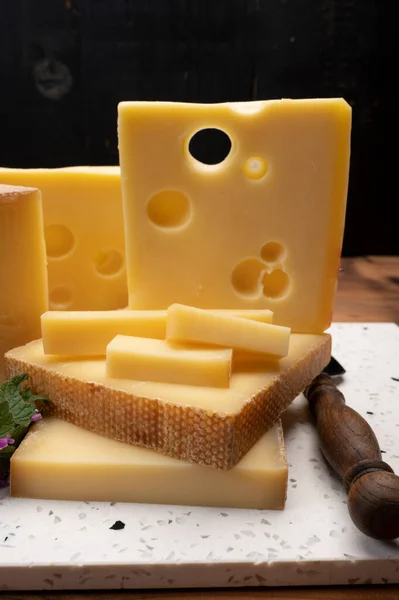 Swiss cheese collection, holes emmentaler and gruyere cheese made from unpasteurized cow\'s milk close up