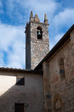 İtalya 'nın Toskana kentindeki Monteriggione tepesindeki ortaçağ kale kasabasındaki eski kasaba duvarlarının içindeki evler.