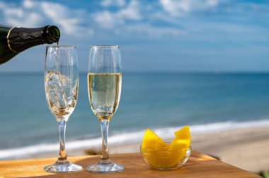 Güneşli bir günde İspanyol Cava şarabı, ananas ve mavi deniz manzaralı açık hava kahvaltısı ve Marbella 'da kumlu plaj, Costa del Sol tatil beldesi, Endülüs, İspanya