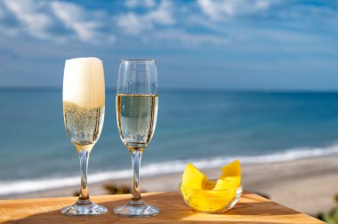 Güneşli bir günde İspanyol Cava şarabı, ananas ve mavi deniz manzaralı açık hava kahvaltısı ve Marbella 'da kumlu plaj, Costa del Sol tatil beldesi, Endülüs, İspanya