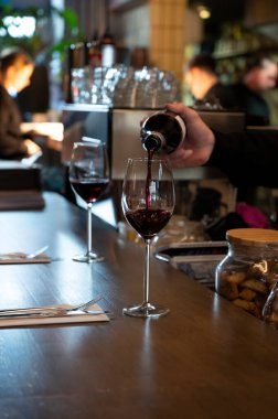İspanyol Bogeda restoranında bardaklara kuru İspanyol tempranillo şarabı dökülüyor.