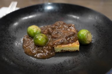 İspanyol tatma menüsü, et soslu patates tortilla ve Brüksel lahanası.