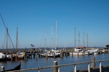 Hollanda 'nın küçük Marken kasabasında güneşli bir bahar gününde eski Hollanda, Hollanda' da bulunan ahşap evlerle yürüyorum.