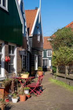 Hollanda 'nın küçük Marken kasabasında güneşli bir bahar gününde eski Hollanda, Hollanda' da bulunan ahşap evlerle yürüyorum.