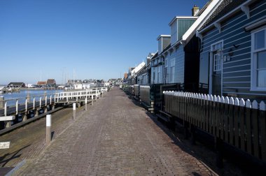 Hollanda 'nın küçük Marken kasabasında güneşli bir bahar gününde eski Hollanda, Hollanda' da bulunan ahşap evlerle yürüyorum.