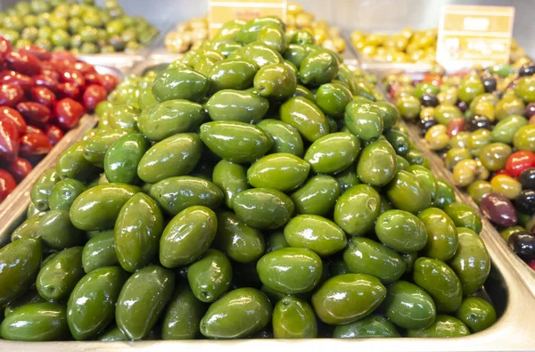 おいしい緑のオリーブは市場で閉じます 健康的な菜食主義者の食品の背景 — ストック写真