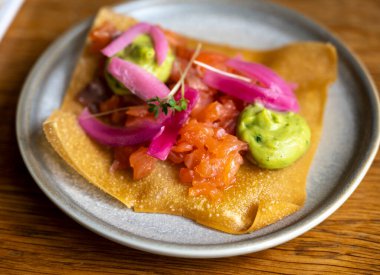 Meksika yemeği, kızarmış mısır tortilla füme somon, guacamole sosu ve pembe soğan turşusu.