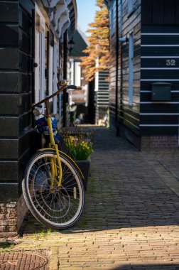 Hollanda 'nın küçük Marken kasabasında güneşli bir bahar gününde eski Hollanda, Hollanda' da bulunan ahşap evlerle yürüyorum.