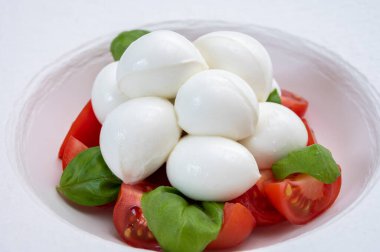 Italian food, tasty caprese salad with red cherry tomatoes, white mozzarella cheese and green basil leaves clipart
