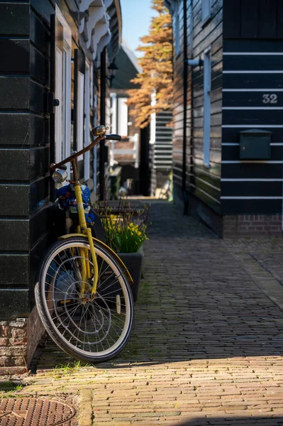 Hollanda 'nın küçük Marken kasabasında güneşli bir bahar gününde eski Hollanda, Hollanda' da bulunan ahşap evlerle yürüyorum.