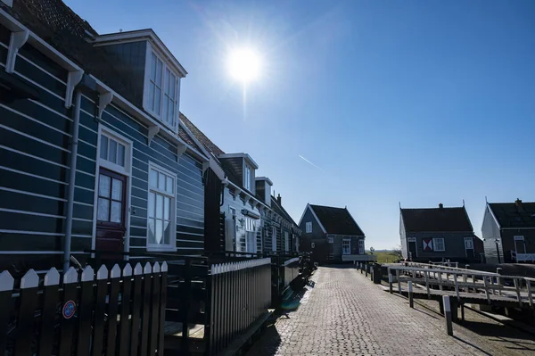 Hollanda 'nın küçük Marken kasabasında güneşli bir bahar gününde eski Hollanda, Hollanda' da bulunan ahşap evlerle yürüyorum.