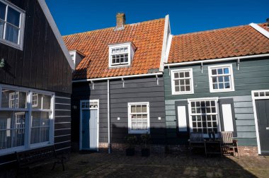 Hollanda 'nın küçük Marken kasabasında güneşli bir bahar gününde eski Hollanda, Hollanda' da bulunan ahşap evlerle yürüyorum.