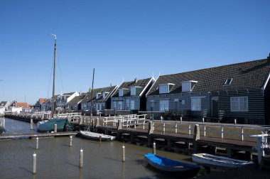 Hollanda 'nın küçük Marken kasabasında güneşli bir bahar gününde eski Hollanda, Hollanda' da bulunan ahşap evlerle yürüyorum.