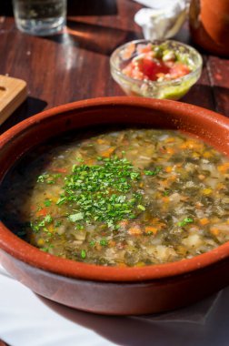 Tenerife 'deki tipik bir Kanarya Adası işletmesi olan Guachinche' de akşam yemeği, yerel olarak üretilen beyaz veya kırmızı şarap ile birlikte güneşli bir günde ev yapımı geleneksel yemekler sunuluyor, gofio ile sebze çorbası.