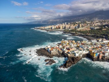 Puerto de la Cruz, Tenerife yakınlarındaki Punta Brava adlı küçük balıkçı köyünde renkli evler ve siyah lav kayaları üzerindeki hava manzarası, kışın İspanya 'da Kanarya Adaları