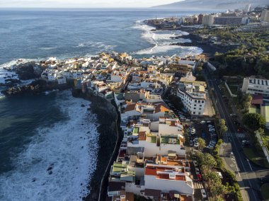 Puerto de la Cruz, Tenerife, Kanarya Adaları yakınlarındaki küçük balıkçı köyünde renkli evlerin ve siyah lav kayalarının hava manzarası.