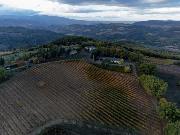 Bagno Vignoni, Tuscany, İtalya yakınlarındaki tepelere bakın. Selvi ağaçları, üzüm bağları, ormanlar ve bulutlu sonbaharda sürülen tarlalarla Toskana manzarası.
