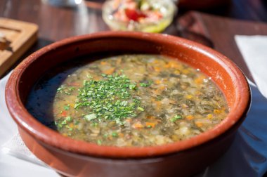 Tenerife 'deki tipik bir Kanarya Adası işletmesi olan Guachinche' de akşam yemeği, yerel olarak üretilen beyaz veya kırmızı şarap ile birlikte güneşli bir günde ev yapımı geleneksel yemekler sunuluyor, gofio ile sebze çorbası.