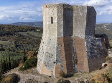 İtalya 'nın Toskana kentindeki tepelerde sonbaharda ortaçağ kalesi ve manzarası