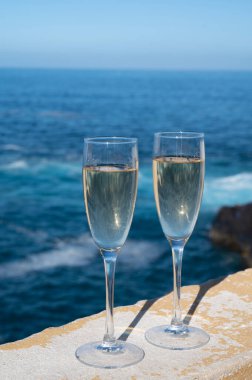 Yeni yıl kutlamalarında iki kadeh şampanya ya da İspanyol kavası köpüklü şarap ve Atlantik 'in mavi suları, Kanarya adaları, kış turistleri