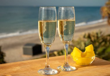 Güneşli bir günde İspanyol Cava şarabı, ananas ve mavi deniz manzaralı açık hava kahvaltısı ve Marbella 'da kumlu plaj, Costa del Sol tatil beldesi, Endülüs, İspanya