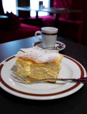 Avusturya 'nın Viyana kentindeki geleneksel kafede bir fincan sade kahveyle servis edilen beyaz peynirli turtayla dolu Avusturya tatlısı.