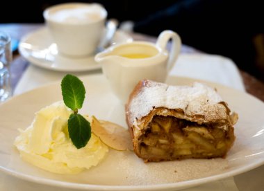 Avusturya tatlısı, krem şantili elmalı turta ve sıcak vanilyalı sos Viyana, Avusturya 'daki eski fırın kafede servis ediliyor.