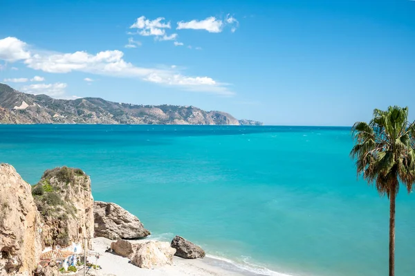 Seyahat yeri, kumlu sahil manzarası, mavi deniz ve dağlar Endülüs 'ün küçük bir kasabası olan Nerja' daki Balcon de Europa 'dan ilkbaharda Costa del Sol, İspanya' da beyaz evleri ve dar sokakları olan