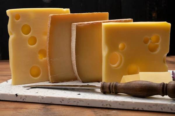 Swiss cheese collection, emmentaler with holes,  gruyere, appenzeller fondue cheeses close up